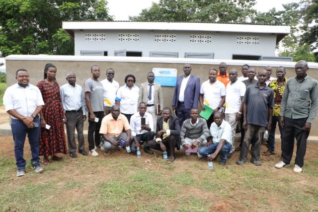 Arua RDC Ham Ezama Muzamil (c), URSB Deputy Registrar General (in blue jacket) after commissioning the Health & Sanitation facility constructed for Oleni Primary School by URSB & partners.