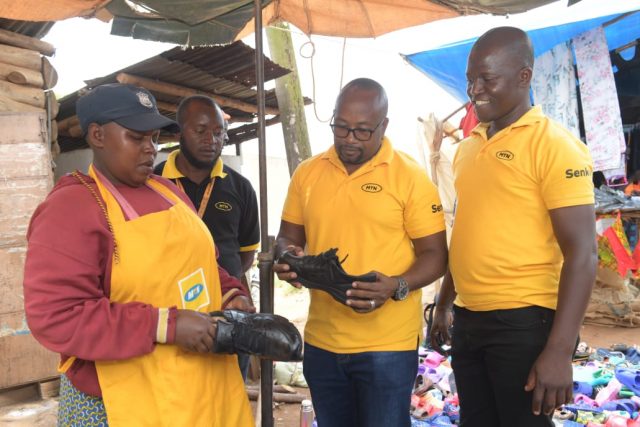 L-R Trader at Masaka Central Market talking to Richard Businge MTN Territory Manager, Patrick Tusiime MTN Commercial Head Central and Denis Ssentongo CCO Representative