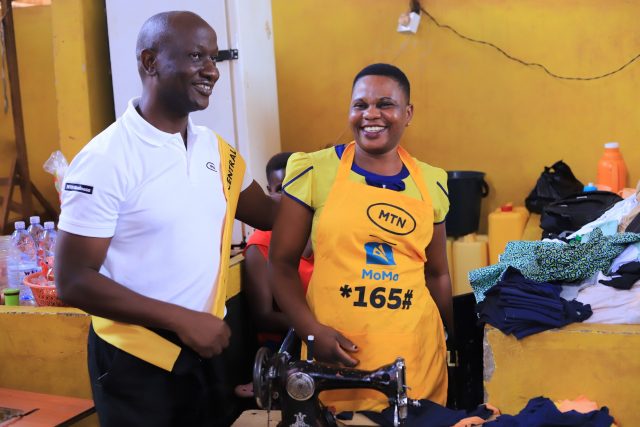 MTN Uganda's Sales and Distribution Manager interacted with one of the tailors at the Jinja Central Market